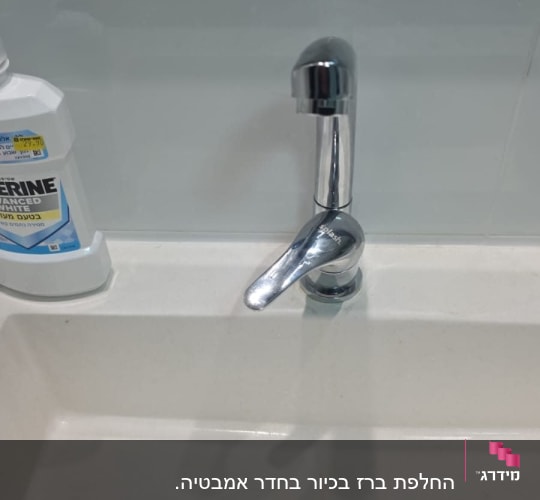 ברז כרום מעל כיור לבן עם ניקוז